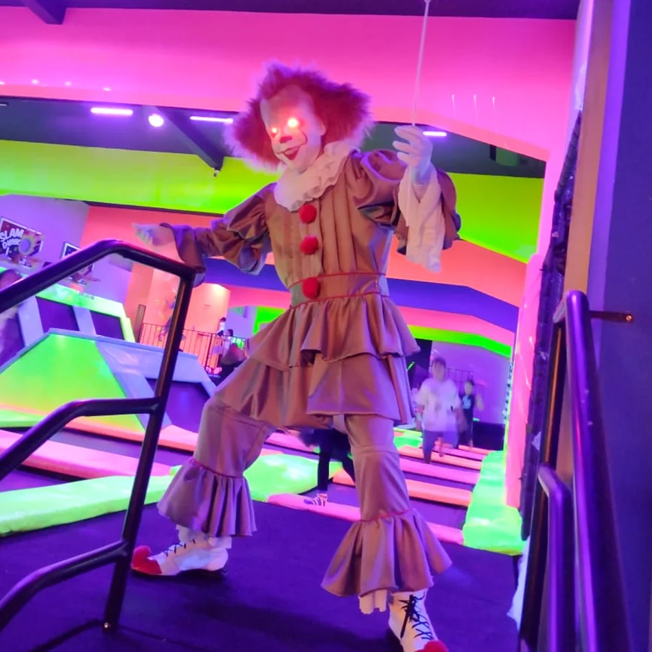 Atração de terror com figurino cinematográfico de Pennywise em recepção corporativa